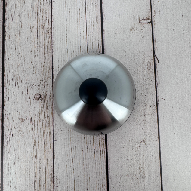 Close-up of the brushed stainless steel lid with matte black knob, a signature detail of the Degrenne Salam collection.